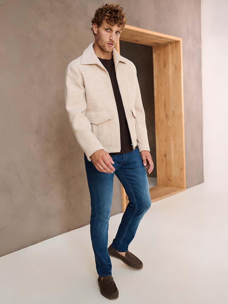 Man in Blauwe Bukser jeans met wollen jas