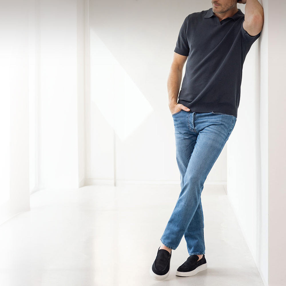 Man in lichtblauwe Bukser jeans met grijze polo