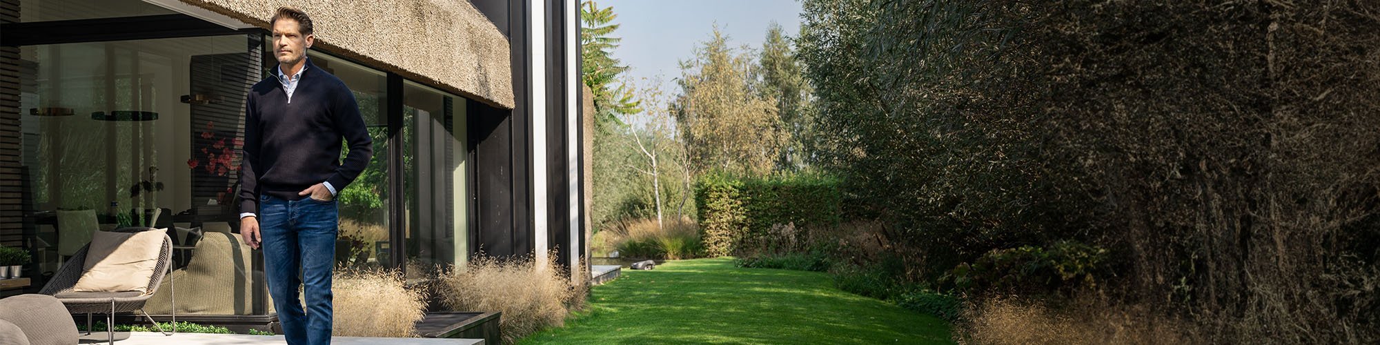 man in donkerblauwe spijkerbroek in tuin
