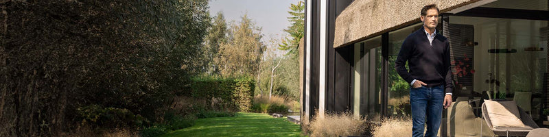 Man in donkere spijkerbroek in de tuin