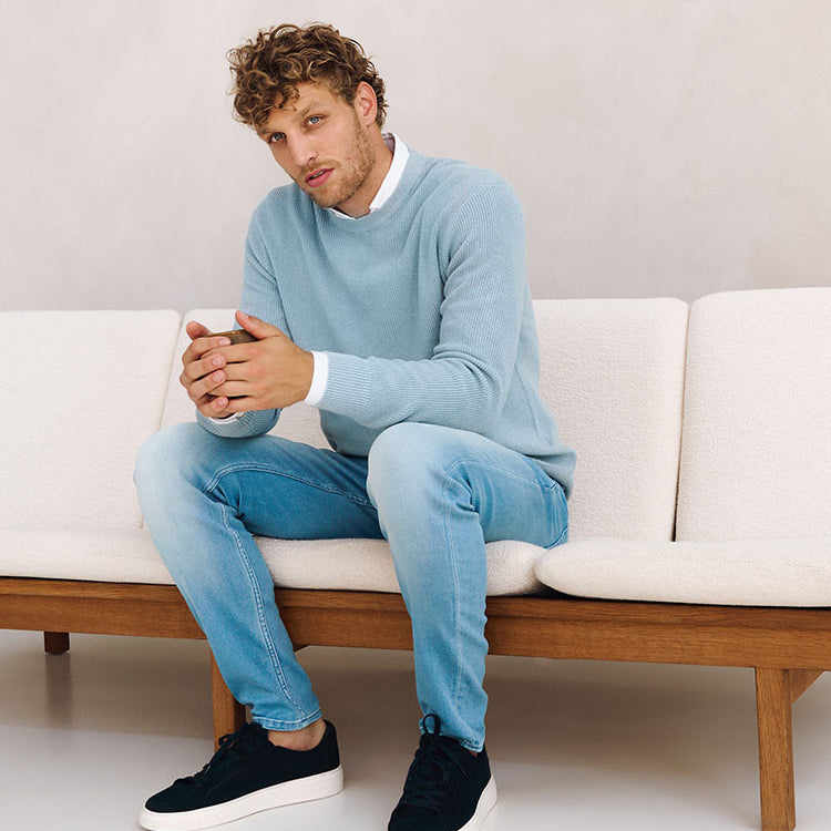 Zittend model in zakelijke lichtblauwe outfit van Bukser jeans