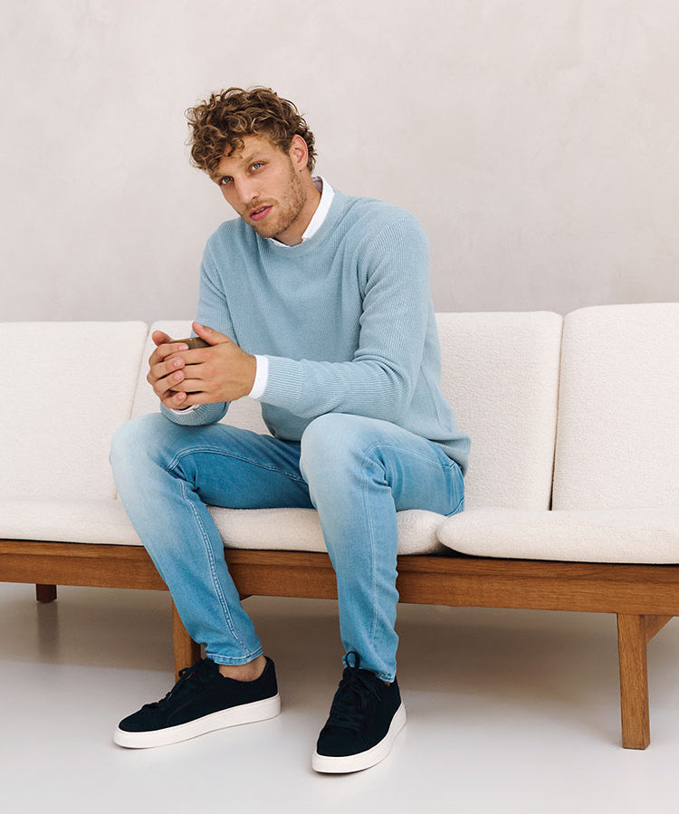 Zittend model in zakelijke lichtblauwe outfit van Bukser jeans