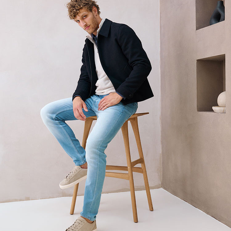 Model zittend op een kruk in lichtblauwe Bukser jeans