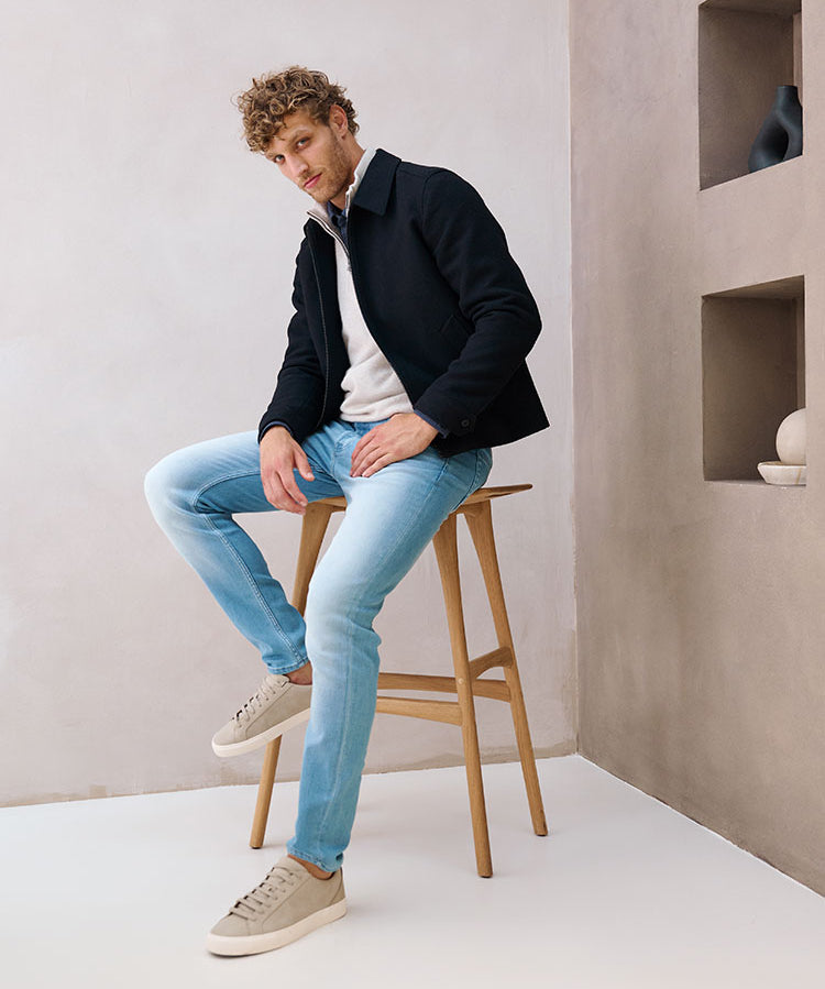 Model zittend op een kruk in lichtblauwe Bukser jeans