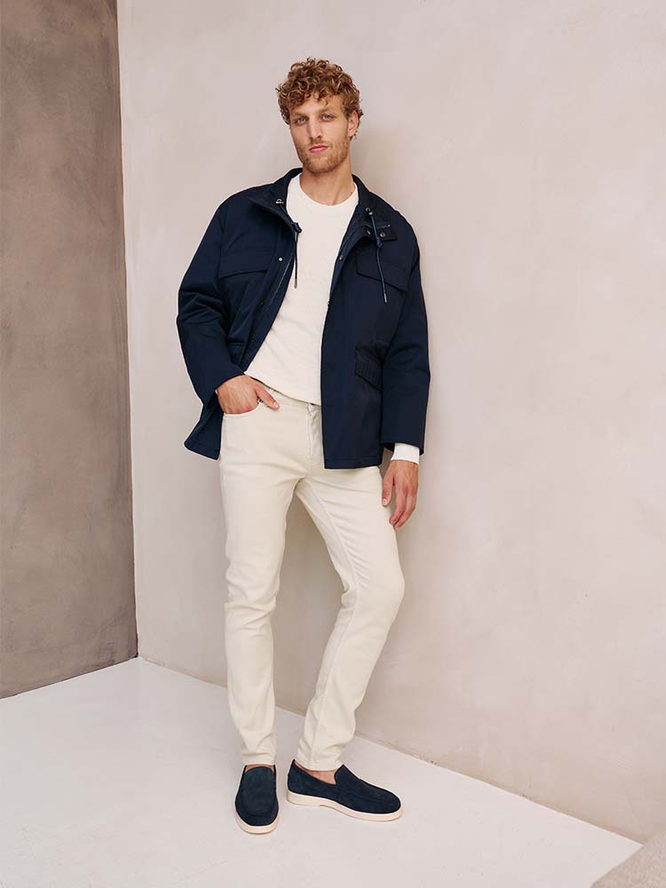 Man in beige Bukser jeans en blauwe jas