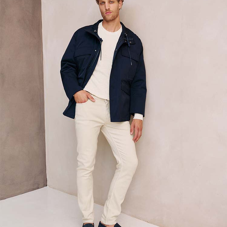 Man in beige Bukser jeans en blauwe jas