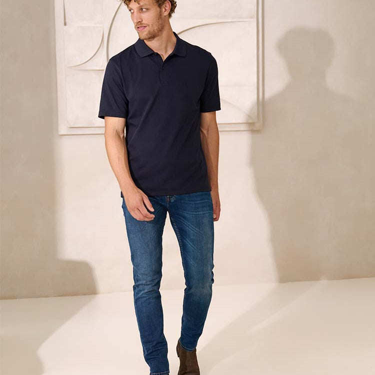 Model in blauwe Bukser jeans en donkerblauwe polo