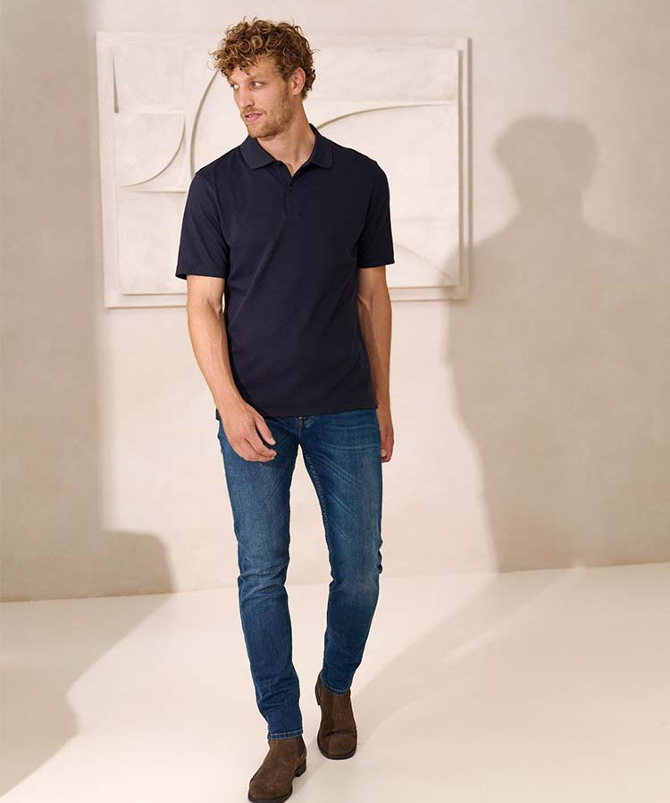 Model in blauwe Bukser jeans en donkerblauwe polo